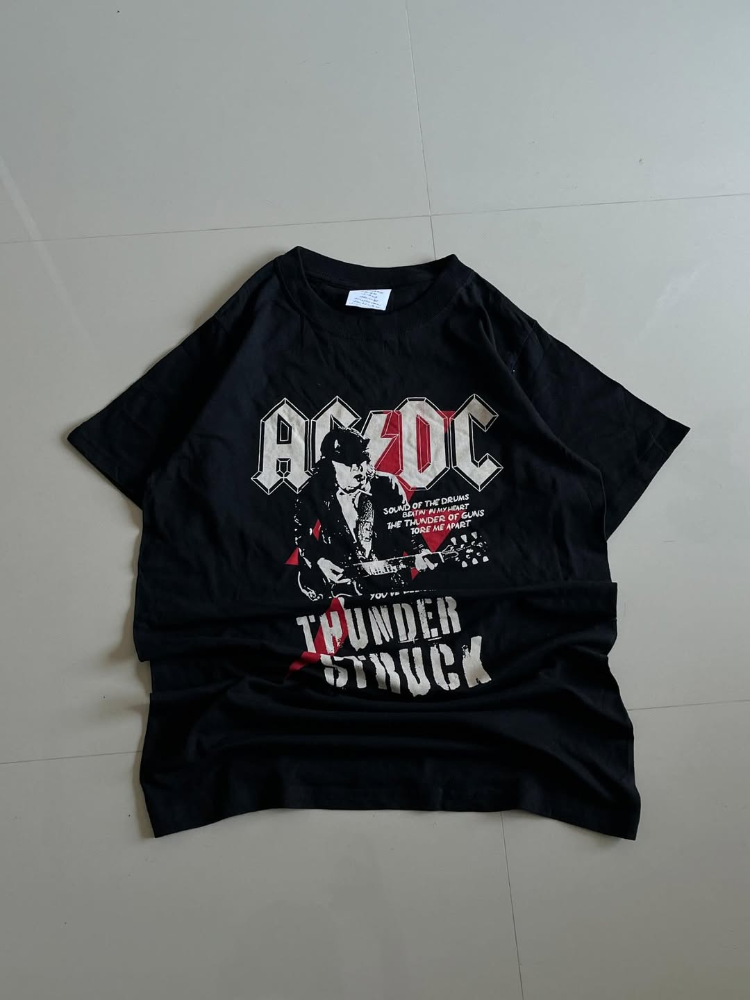 Black JUNKFITS t-shirt featuring AC/DC logo, Angus Young artwork, and Thunderstruck lyrics