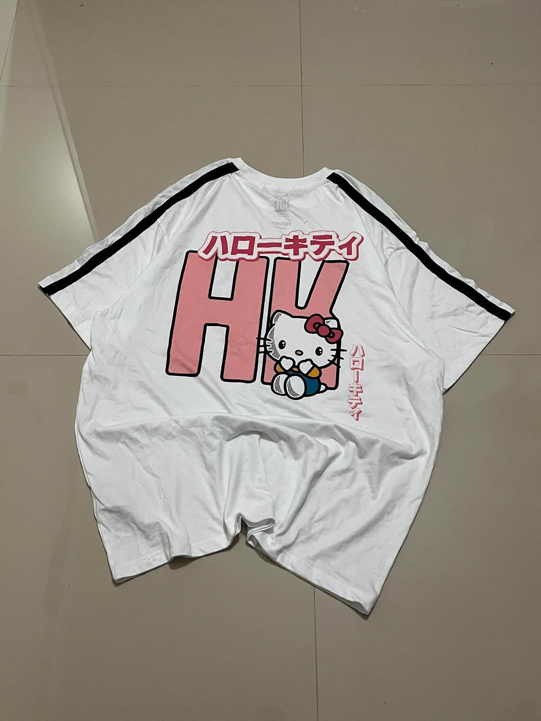  White oversized tee with pink “HK”, Hello Kitty character, and vertical Japanese text