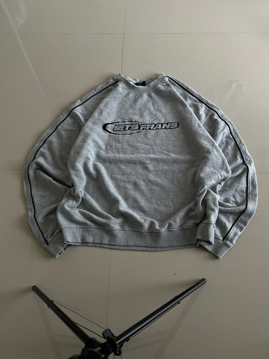 JUNKFITS grey oversized sweatshirt front view with black chest print and piping on sleeves.