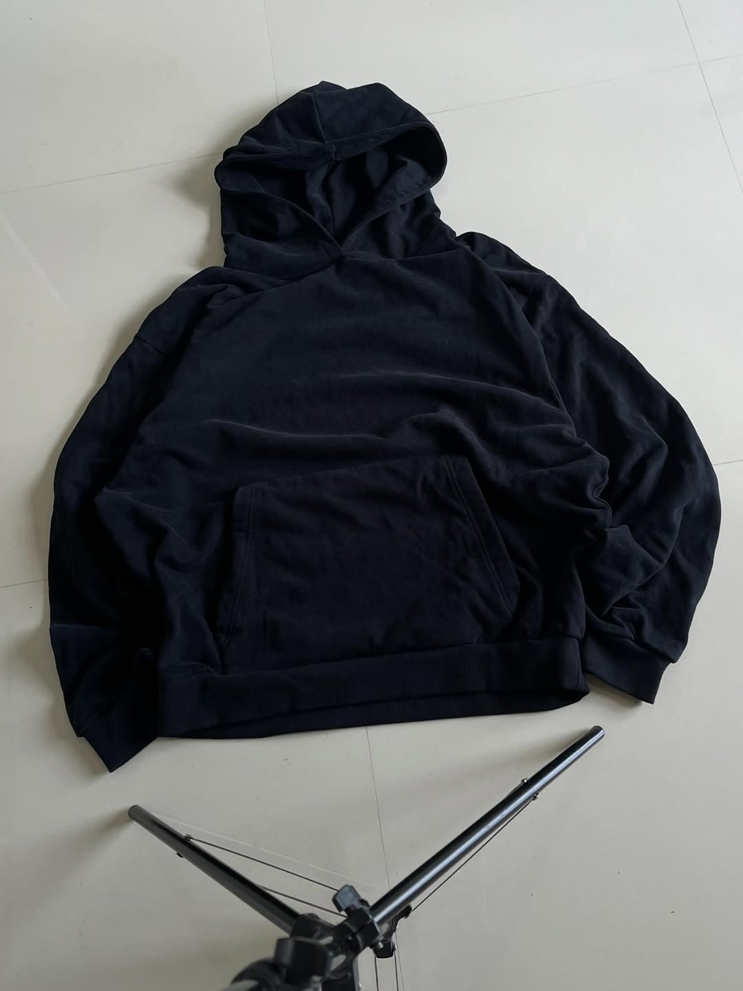 JUNKFITS oversized black hoodie front view showing hood and kangaroo pocket.