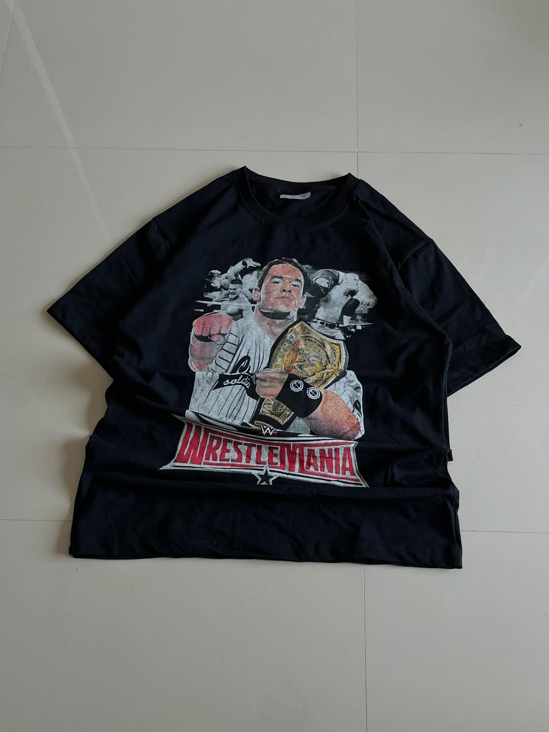 Black JUNKFITS t-shirt featuring a champion wrestler graphic with championship belt and WrestleMania logo

