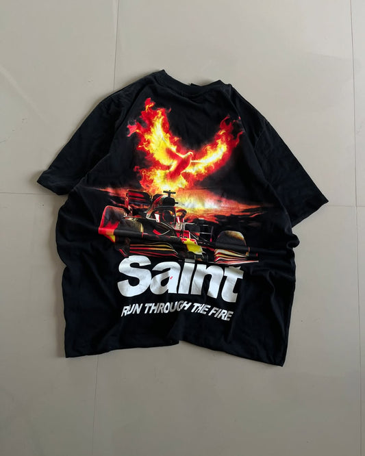 Back view of black oversized Saint tee with Formula 1 car and fiery phoenix graphic, text “Run Through The Fire” by Junk Fits

