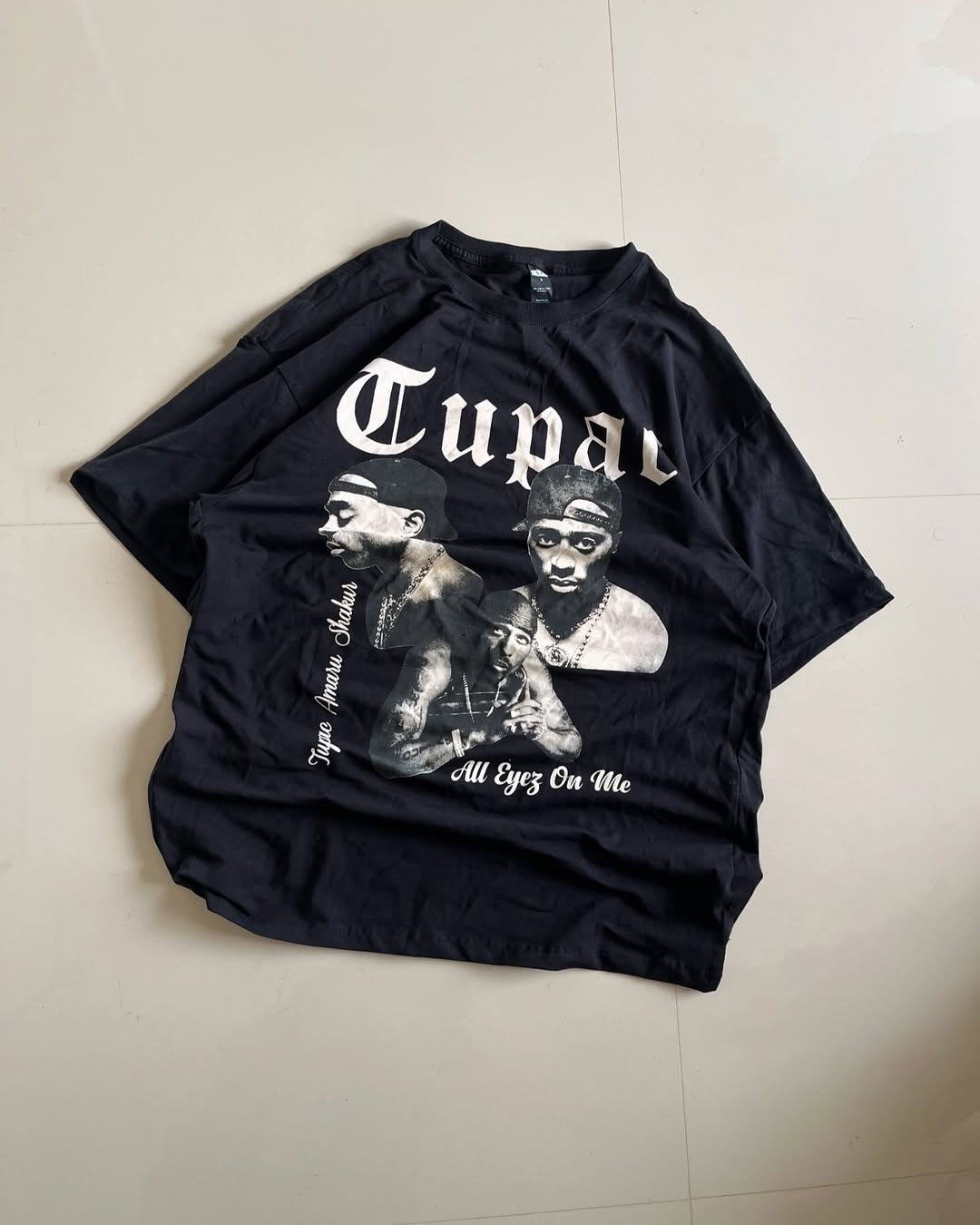 Black Tupac "All Eyez On Me" t-shirt featuring portrait collage and gothic font

