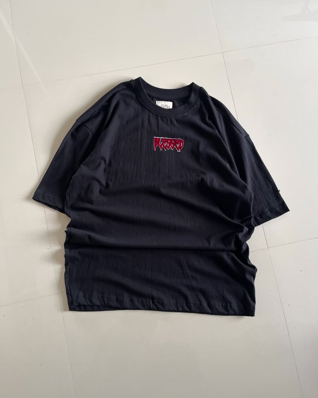 Oversized black t-shirt with twin skeleton graphic and red gothic-style lettering on the back